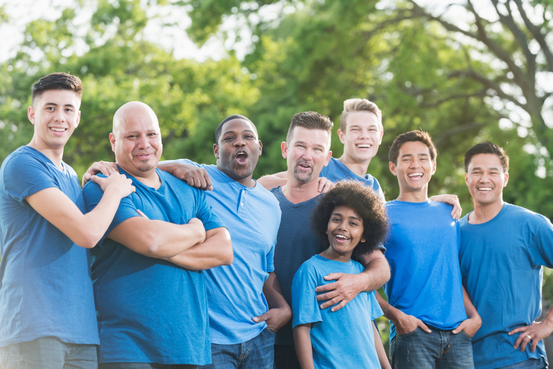 Multi-racial group of fathers and sons volunteering